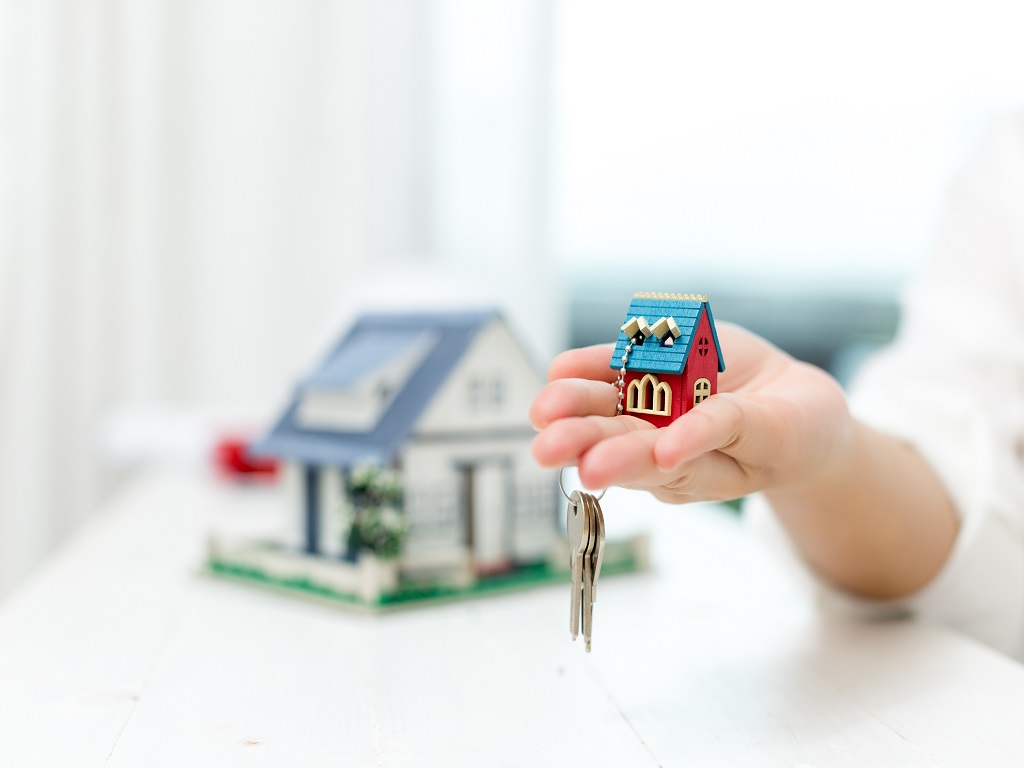 real estate agent with house model keys image